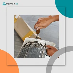Hands using a screwdriver on a small condenser coil reached through the back of a unit