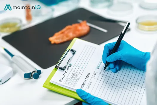 Gloved hand filling in a paper quality control form on a clipboard next to a raw salmon fillet